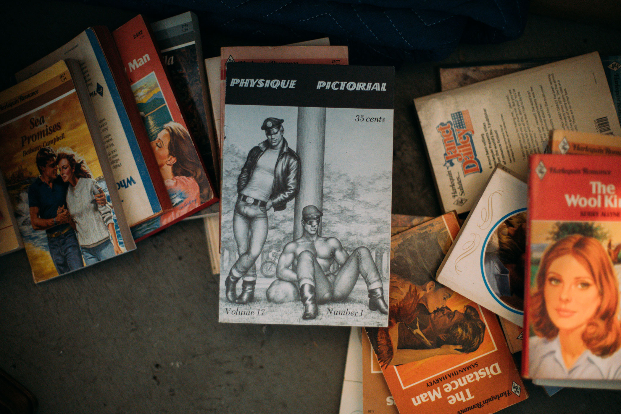 Queerskins installation on Canal Street. A close up of romance novels amongst vintage Tom of Finland.